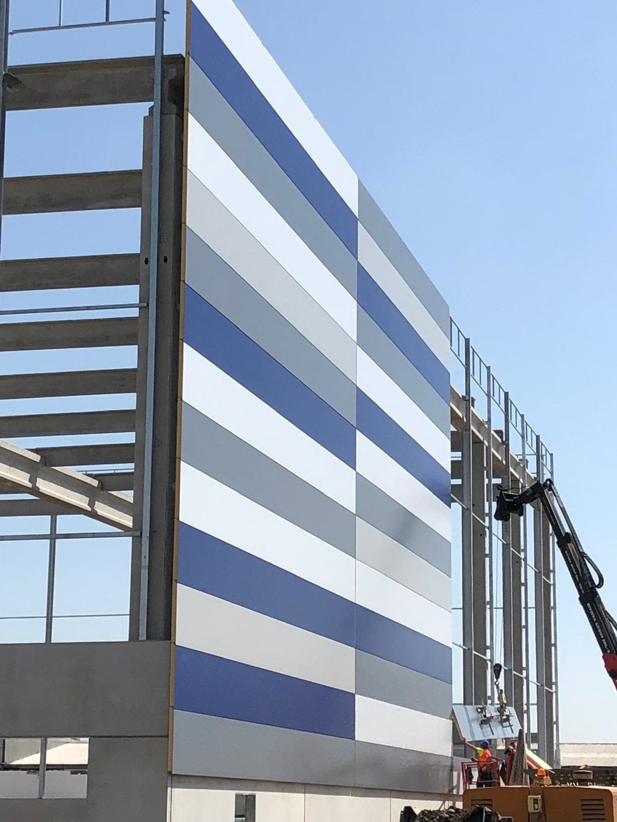 Nuovo edificio industriale in costruzione con struttura prefabbricata e facciata a pannelli